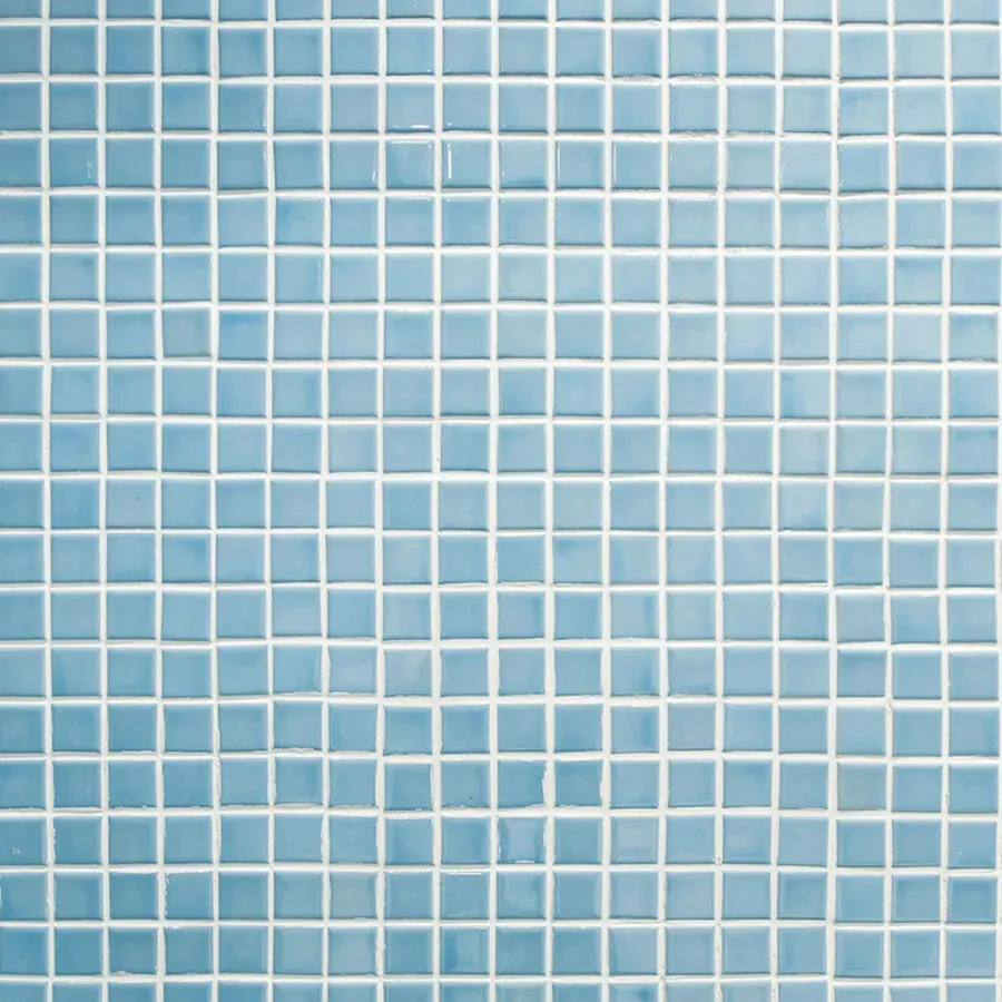 A close up of a light blue mosaic tile wall.