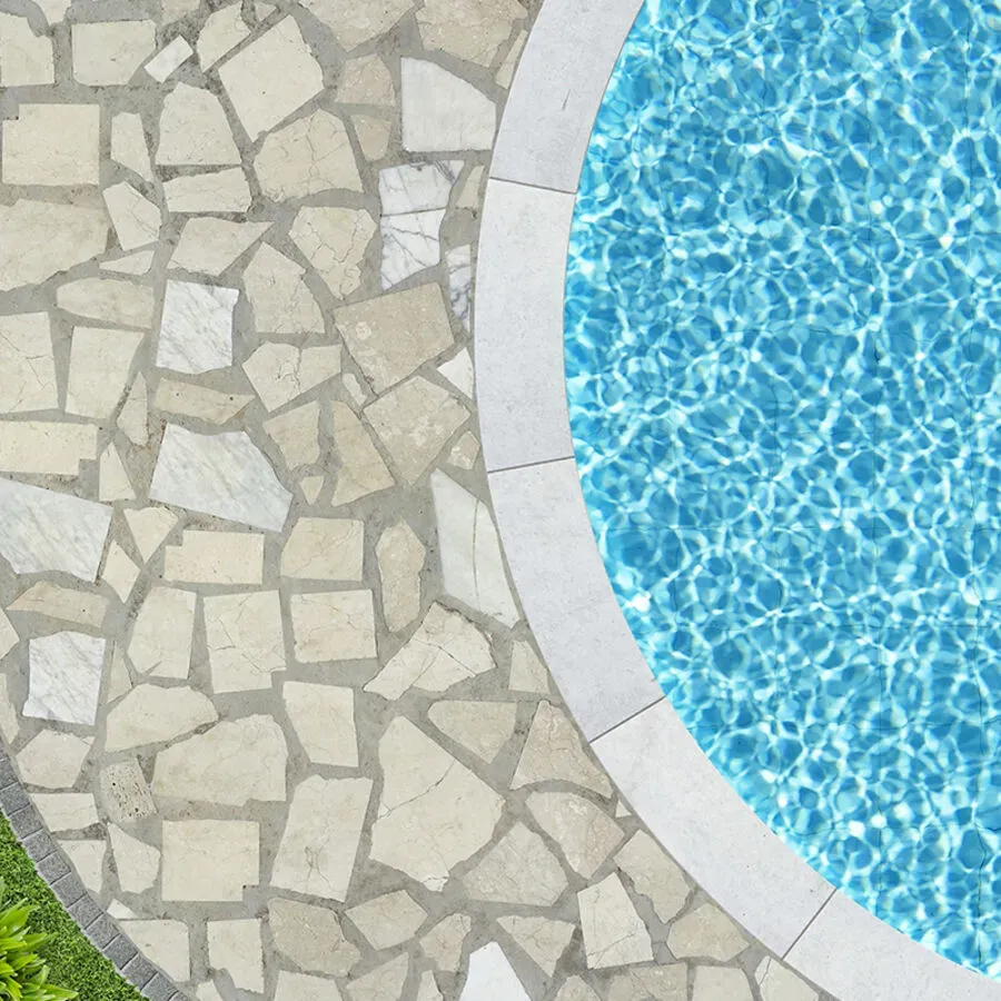 A swimming pool with a stone walkway next to it